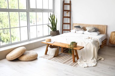 Odanın içinde ahşap banklar ve bitkiler var.