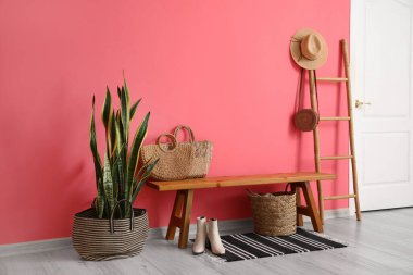 Ahşap bankları, hasır çantaları ve merdivenleri olan şık bir salon.