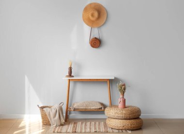 İçinde masa, puf ve vazo olan şık bir oda.