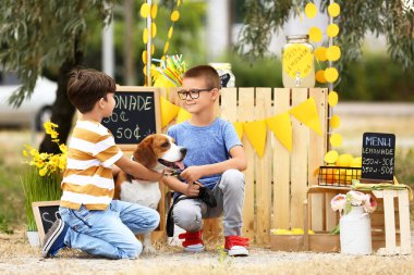 Parktaki limonata standının yanında köpekli şirin çocuklar.