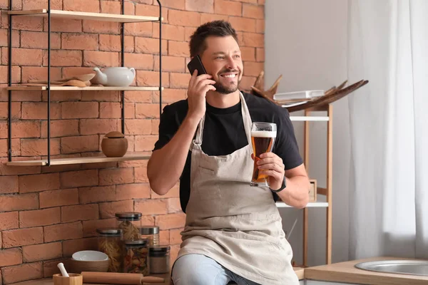 Bonito Homem Bebendo Cerveja Enquanto Fala Por Telefone Cozinha — Fotografia de Stock