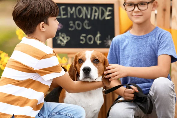公園のレモネードスタンドの近くに犬とかわいい子供たち — ストック写真