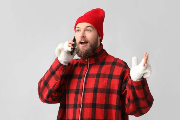 Молодой Бородатый Мужчина Теплых Перчатках Разговаривает Мобильному Телефону Светлом Фоне — стоковое фото