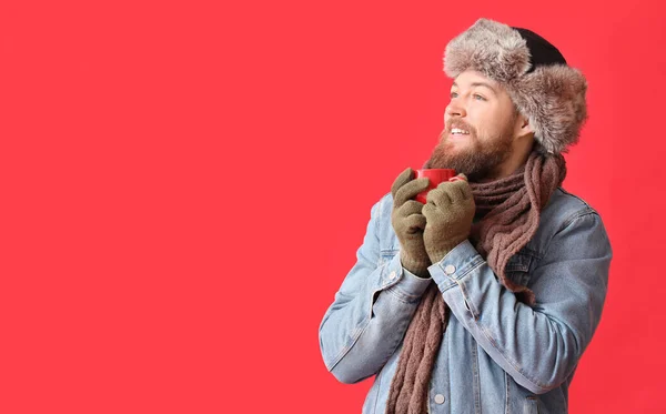 Молодой Бородатый Мужчина Теплых Перчатках Чашкой Какао Красном Фоне — стоковое фото