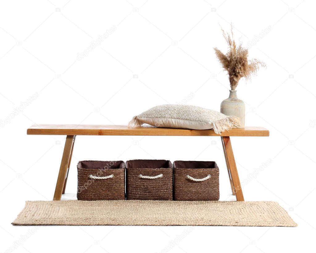 Wooden bench with pillow, vase, baskets and rug on white background