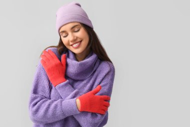 Kırmızı eldivenli ve açık renk şapkalı genç bir kadın.