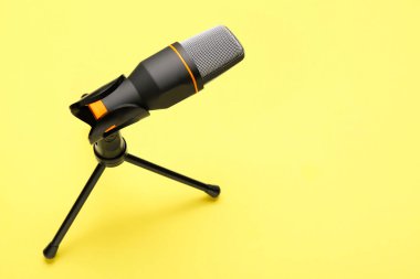 Sarı arka planda modern mikrofonun yanında dur