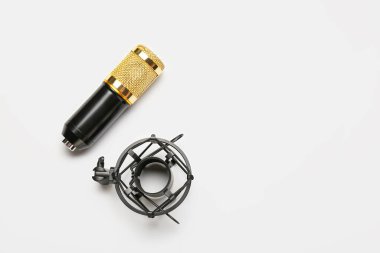 Işık arkaplanı üzerinde duran modern mikrofon