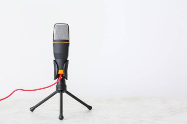 Işık arka planında modern mikrofonun yanında dur