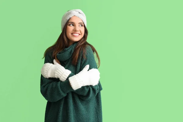 Молодая Женщина Теплых Перчатках Обнимает Себя Зеленом Фоне — стоковое фото