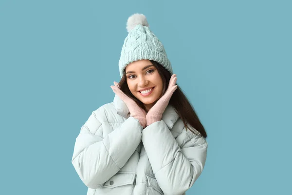 戴着蓝色背景的温暖手套和帽子的年轻女子 — 图库照片