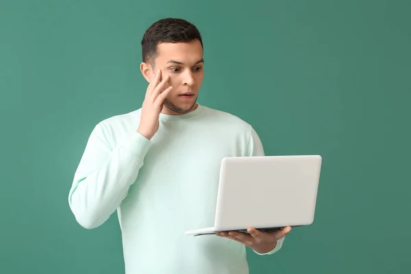 Chockad Ung Man Med Bärbar Dator Grön Bakgrund — Stockfoto