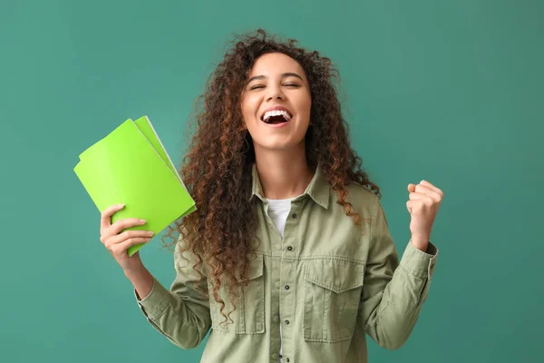 緑の背景にノートを持つ幸せな若いアフリカ系アメリカ人女性 — ストック写真
