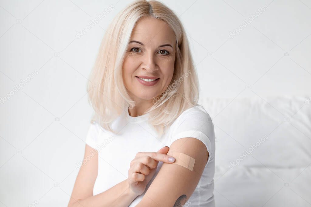 Mature woman applying nicotine patch at home. Smoking cessation