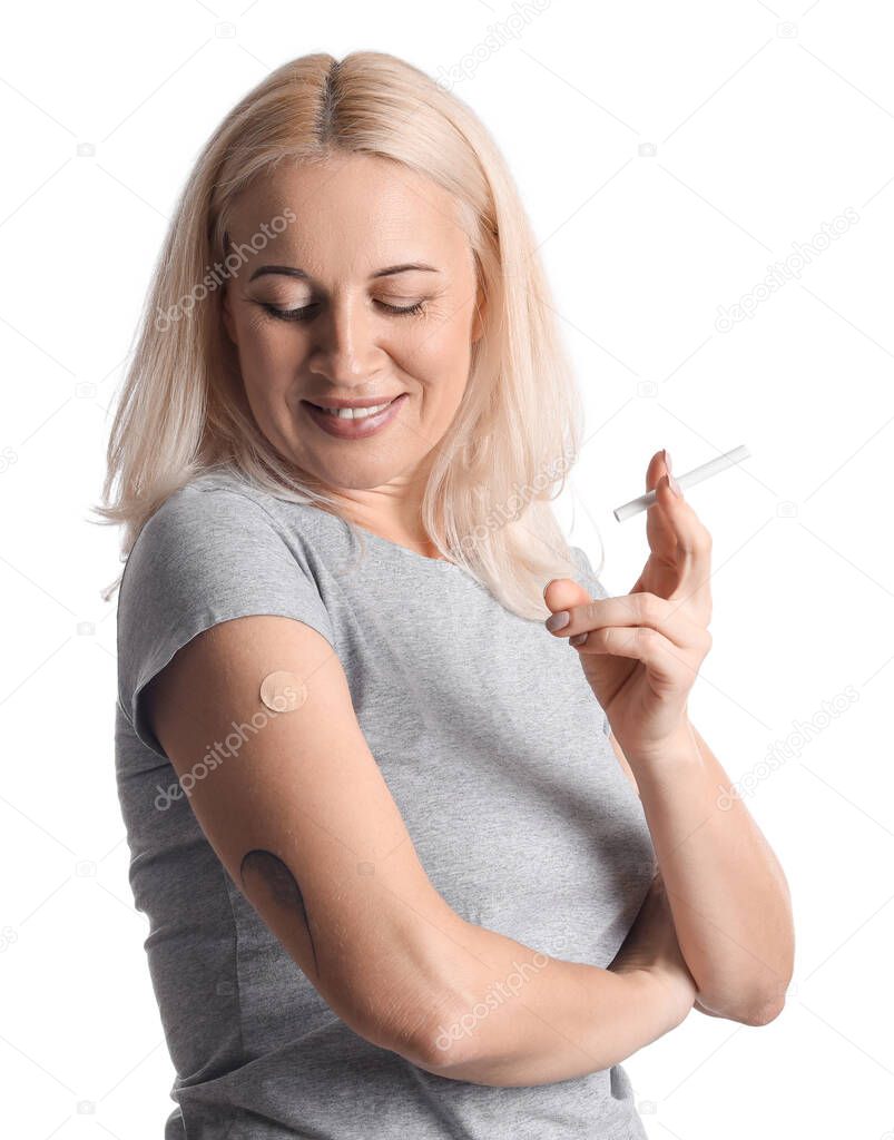 Mature woman with applied nicotine patch and cigarette on white background. Smoking cessation
