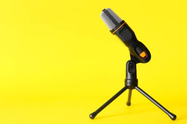 Sarı arka planda modern mikrofonun yanında dur