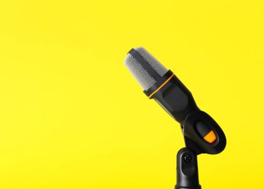 Sarı arka planda modern mikrofonun yanında dur