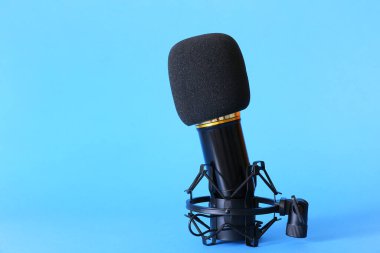 Mavi arka planda modern mikrofonun yanında dur