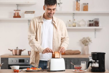 Genç adam mutfakta lezzetli tost yapıyor.