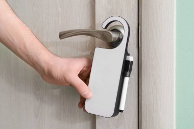 Otel odasında kapı askısı olan adam, yakın plan.