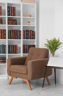 Modern oda içinde koltuklu bir kitaplık.