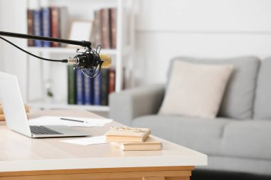 Laptop, kitap ve mikrofonlu modern işyeri