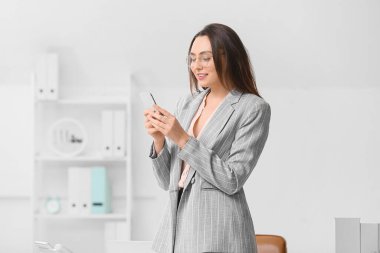 Ofisinde telefonu olan genç sekreterin portresi.