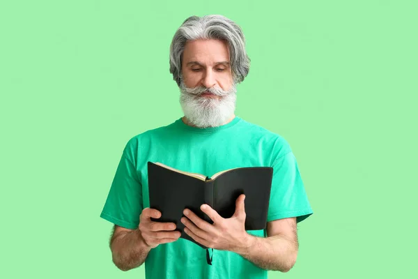 Homem Sênior Lendo Bíblia Sagrada Fundo Verde — Fotografia de Stock