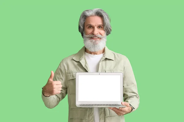 Starší Muž Notebookem Ukazující Palec Nahoru Zeleném Pozadí — Stock fotografie