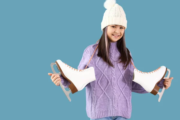 小さなアジアの女の子で暖かい服とともにアイススケート上の青の背景 — ストック写真