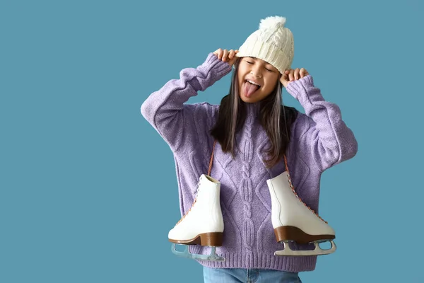 穿着保暖衣服的亚洲小女孩 溜冰鞋上有蓝色背景的舌头 — 图库照片