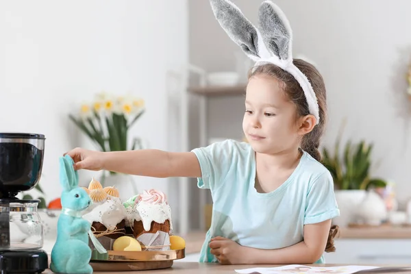可愛いです女の子とともにイースターケーキとウサギでキッチンに自宅 — ストック写真