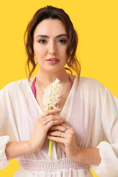 Hübsche Junge Frau Mit Hyazinthenblüten Auf Gelbem Hintergrund — Stockfoto