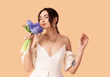 Arka planda sümbül çiçekleri olan güzel genç bir kadın.