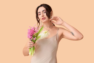 Arka planda sümbül çiçekleri olan güzel genç bir kadın.