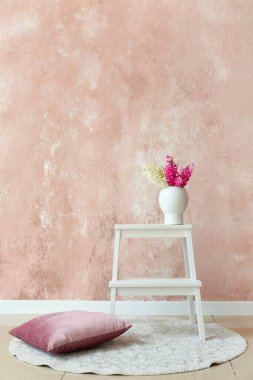 Sümbül çiçekli merdiven taburesi ve odanın renk duvarının yanındaki yastık.
