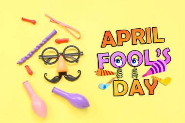 Sarı arkaplanda parti dekorasyonu ve APRIL FOOL Günü metin kompozisyonu
