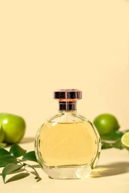 Açık renkli arkaplanda bir şişe narenciye parfümü