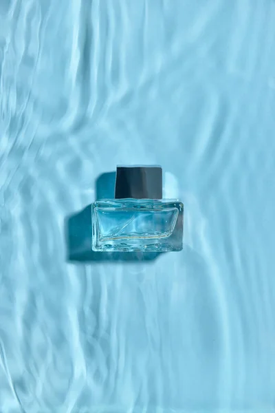 Renkli Arka Planda Suda Bir Şişe Parfüm Üst Görünüm — Stok fotoğraf