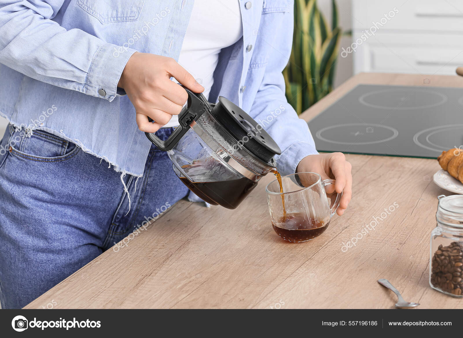Download Young woman pouring hot coffee from pot in kitchen — Stock Image
