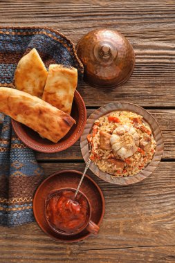 Geleneksel pilav, domates sosu ve ekmek tabağı.