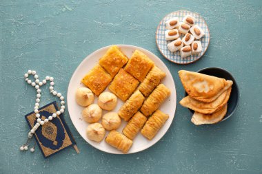 Geleneksel doğu yemekleri ve gri arkaplanda tasbih.