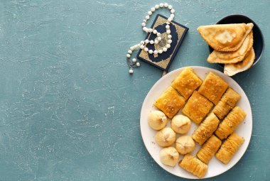 Geleneksel doğu yemekleri ve gri arkaplanda tasbih.