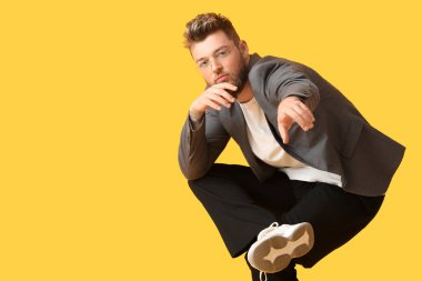 Renkli arka planda havalı dans eden genç adam.