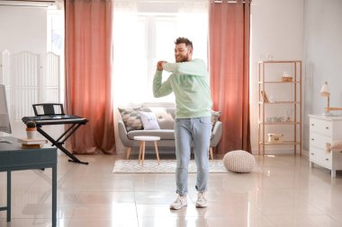 Havalı genç adam evde dans etmeyi öğreniyor.