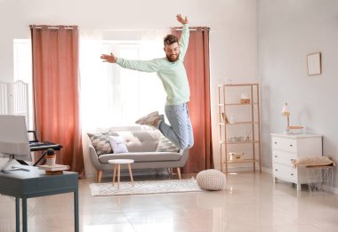 Evde dans eden havalı genç adam.