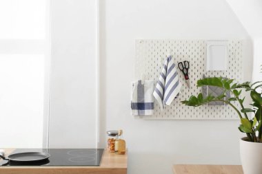 Işık duvarında havlular, makas ve defter olan tahta.