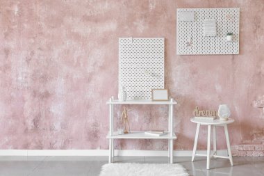 Pembe desenli duvar zemininde tahta olan şık raf ünitesi