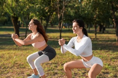 Parkta genç kız kardeşler antrenman yapıyor.