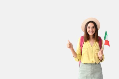 İtalyan bayrağı taşıyan kadın turist, arka planda baş parmak gösteriyor.